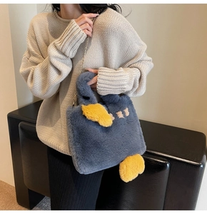 Détail du sac à main en peluche bleu foncé avec ailes 3D et chaîne dorée