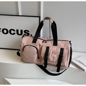 Vue détaillée du sac de voyage rose avec poches zippées et sangles réglables noires