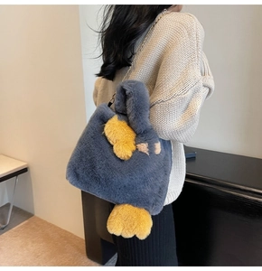 Détail du sac cabas en peluche grise avec ailes jaunes et bandoulière en chaîne