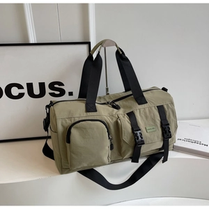 Détail du sac de fitness vert montrant la texture en nylon étanche et les poches de rangement