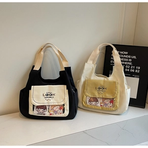 Close-up of black and cream canvas tote bags with transparent front pockets and top handles