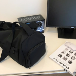 Detail of black sports gym bag with independent side zipper compartment on white desk
