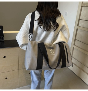 Dettaglio borsa fitness grigia con logo NINGJIA e tracolla regolabile in nylon nero