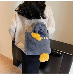 Détail du sac canard en peluche avec chaîne dorée sur fausse fourrure bleu grisâtre