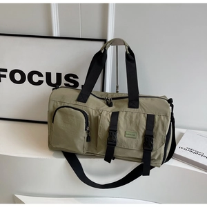 Détail du sac de sport vert olive avec poche à boucle avant et étiquette tissée MINGJIA