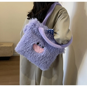 Détail du sac cabas monstre en peluche violette avec broderie porté par un mannequin