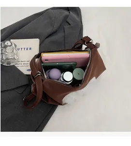 Top view of a large brown shoulder bag interior holding a tablet and daily essentials