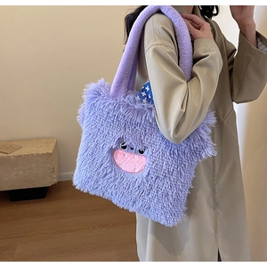 Détail d'un sac cabas en peluche violette avec visage de monstre et bandoulière épaisse douce