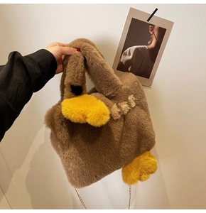 Détail du sac canard en peluche marron avec bec jaune et bandoulière dorée