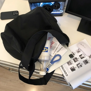 Top view of large black nylon travel bag showing spacious interior with laptop and books