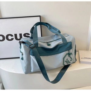 Détail du sac de sport bleu bicolore avec bandoulière réglable et poche latérale