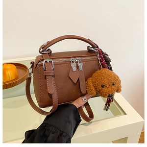 Détail du sac polochon marron avec fermeture éclair double et pendentif ours doux