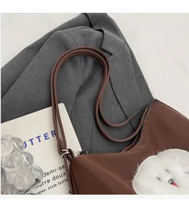 Detail of durable brown nylon shoulder straps and cute plush bunny patch on a tote bag