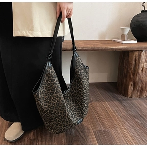 Detail of large leopard print hobo bag with black leather trim and soft fabric texture
