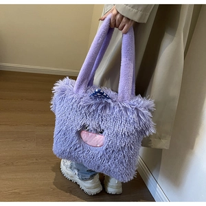 Gros plan sur la texture en peluche violette et la broderie de monstre du sac fourre-tout
