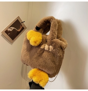Détail du sac cabas canard en peluche marron avec bec jaune et bandoulière dorée
