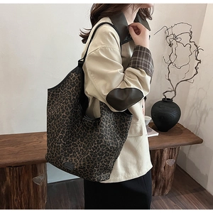 Model wearing a large leopard print tote bag with black trim for stylish daily commute