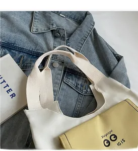 Detail view of durable canvas tote bag with contrast yellow webbing handles and inserts