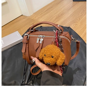 Détail du sac vintage marron à texture grainée avec pendentif chien en peluche