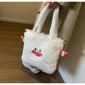 Détail du sac cabas monstre en peluche blanche avec broderie et cornes rayées en 3D