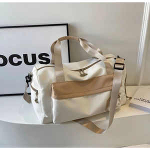 Détails du sac de voyage avec fermetures en métal et sangles contrastées en beige