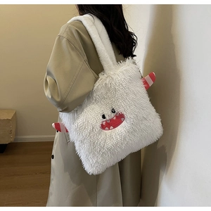 Sac fourre-tout monstre en peluche blanche porté avec un manteau beige élégant