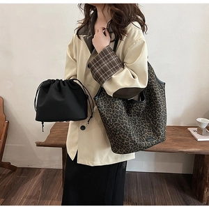 Detail view of large leopard print tote bag with black drawstring bucket liner bag