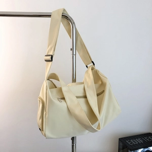 Macro detail of cream sports gym bag with multi-zipper pockets and adjustable strap