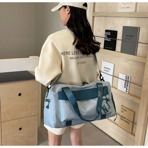 Détail du sac de fitness bleu gris avec sangles vertes et logo NJ pour sport ou voyage
