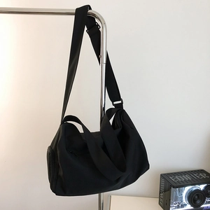Detail view of the black waterproof nylon gym bag featuring side zipper pocket and straps