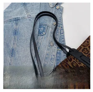Close-up of leopard print tote bag featuring black leather handles and UZ FASHION tag