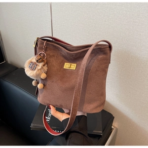 Detail of leopard print retro bucket bag with plush bear charm and golden metal clasp