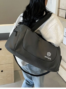 Large gray travel bag with separate wet and dry compartments carried by a person