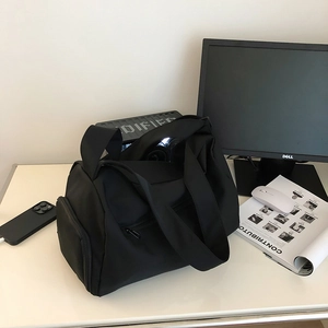 Detailed view of the separate zipper shoe compartment on a black sports duffel bag