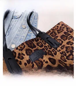 Close-up of leopard print tote bag with UZ FASHION brand patch and leather straps