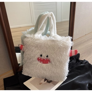 Détail du sac cabas monstre en peluche blanche avec cornes rouges et visage brodé