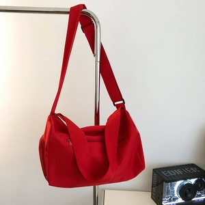 Detail view of the durable red nylon gym bag showing wide strap and side zipper pocket