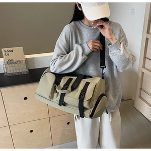 Détail du sac de voyage en toile vert olive avec bandoulière réglable sur un mannequin