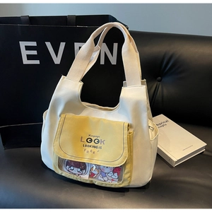 Detail of cream canvas tote bag featuring yellow flap pocket and transparent PVC window