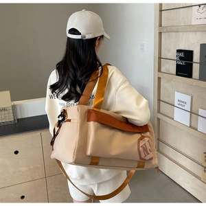Détail d'un grand sac de yoga beige avec anses orange et logo N.J minimaliste