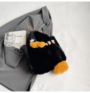 Détail du sac peluche pingouin avec touches jaunes et fine bandoulière chaîne dorée