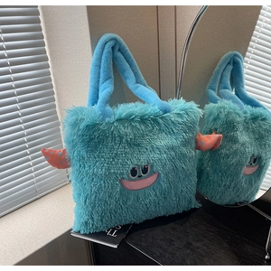 Détail du sac cabas monstre bleu en peluche douce avec visage de dessin animé brodé