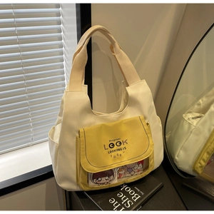 Detail of canvas tote bag featuring yellow PVC transparent window and side pockets