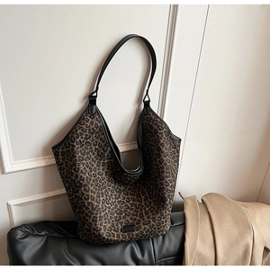 Detail of leopard print tote bag with black leather trim and smooth shoulder strap