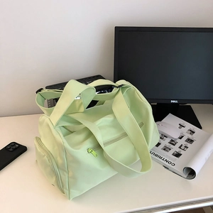 Detail view of mint green waterproof nylon gym bag with adjustable shoulder strap