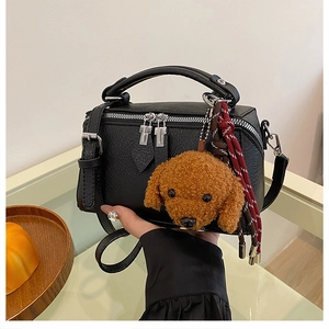 Détail du sac polochon rétro en cuir noir texturé avec zips et breloque ourson