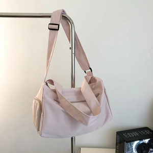 Detail view of pink waterproof nylon gym bag with adjustable strap and side zipper pocket