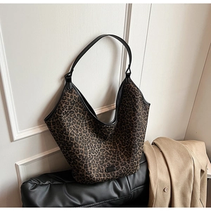 Detail of leopard print hobo bag with black leather strap on a studio bench