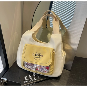 Detail of canvas tote bag featuring contrast pockets and a transparent clear window