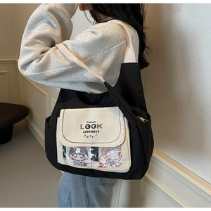 Detail of a large black canvas tote bag with contrast beige pocket and clear window